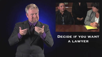 A man is signing is ASL. In the background is a litigant and an attorney with the following text overlaid: Decide if You Want a Lawyer