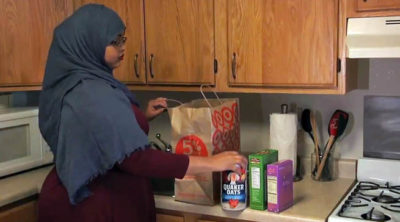 Photo of a Somali woman in a kitchen unloading groceries